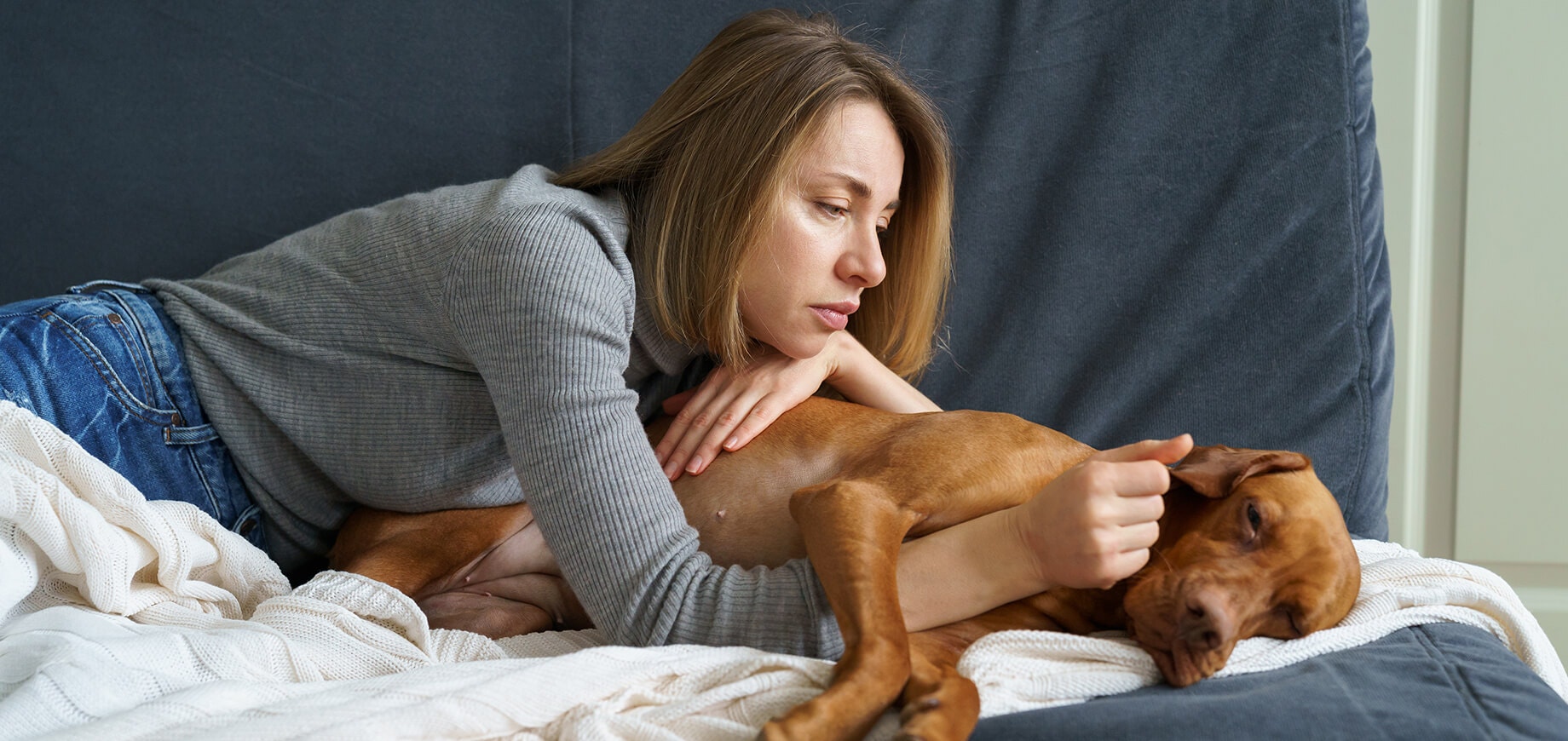 kobieta z blond włosami leżąca na kanapie z psem